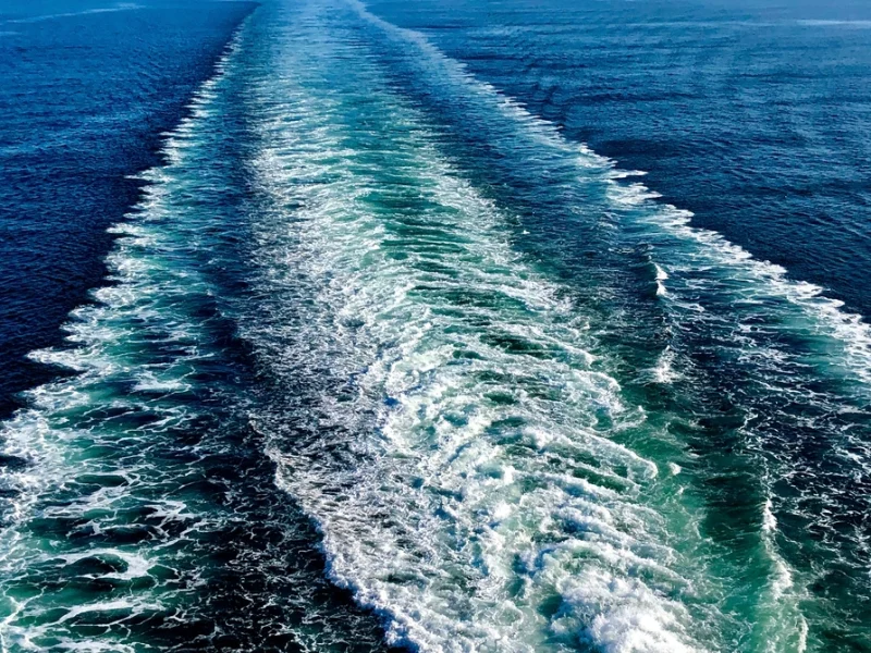 Speedboat wake cutting across blue open sea