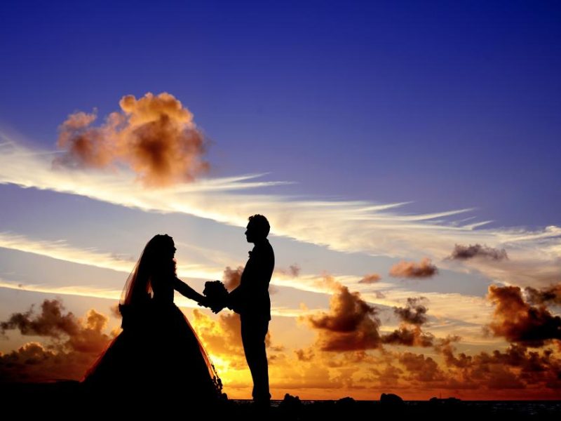 Couple watching sunset on a tropical beach