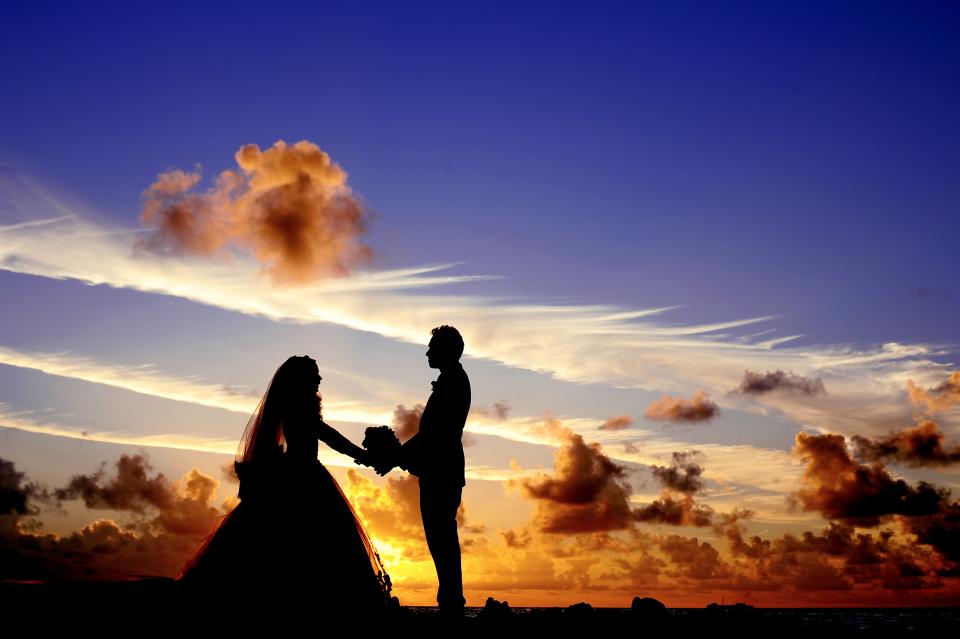 Couple watching sunset on a tropical beach